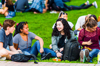 young students sitting outside together